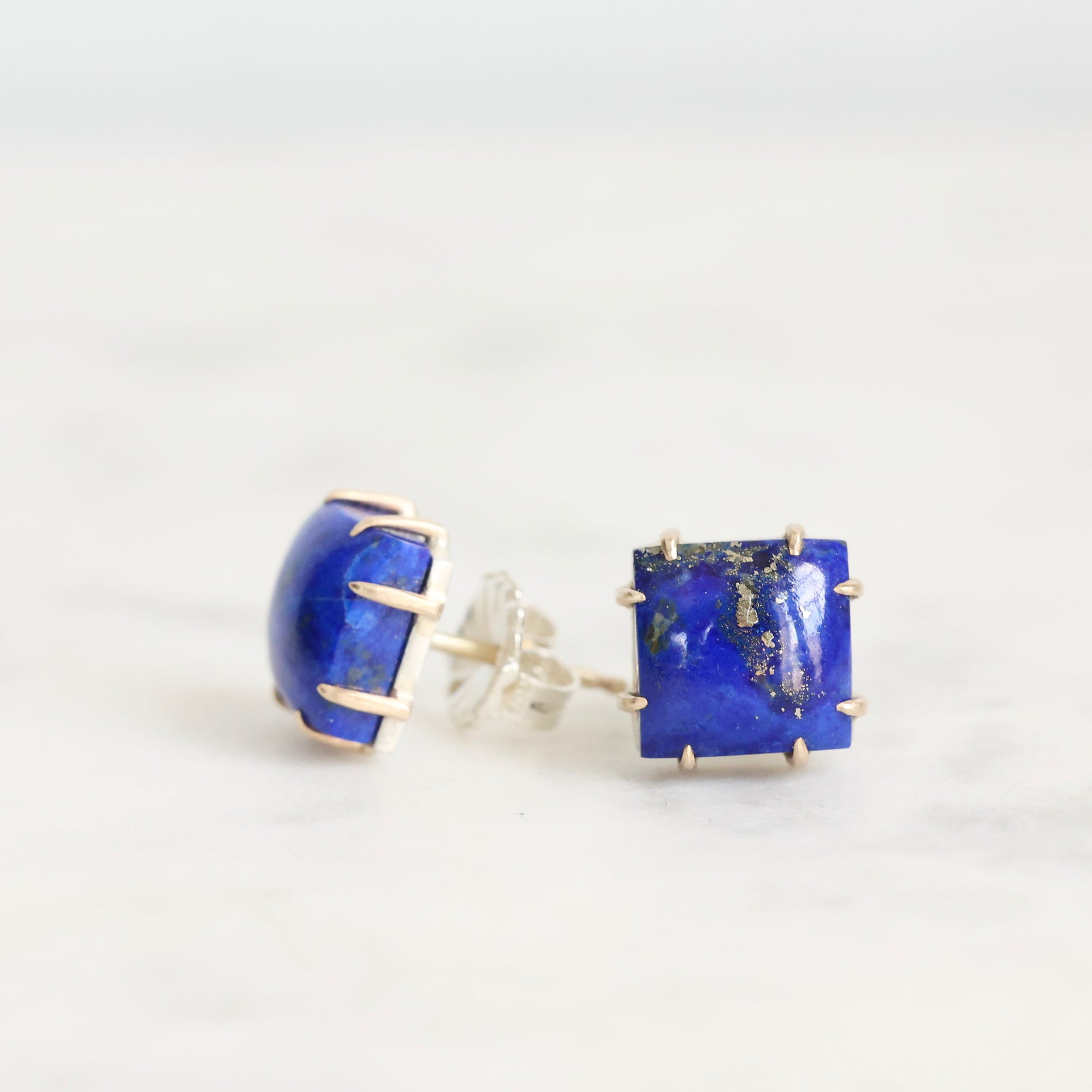 Pair of blue gemstone earrings on a white background