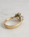 Gold ring with diamond accents on a light gray background