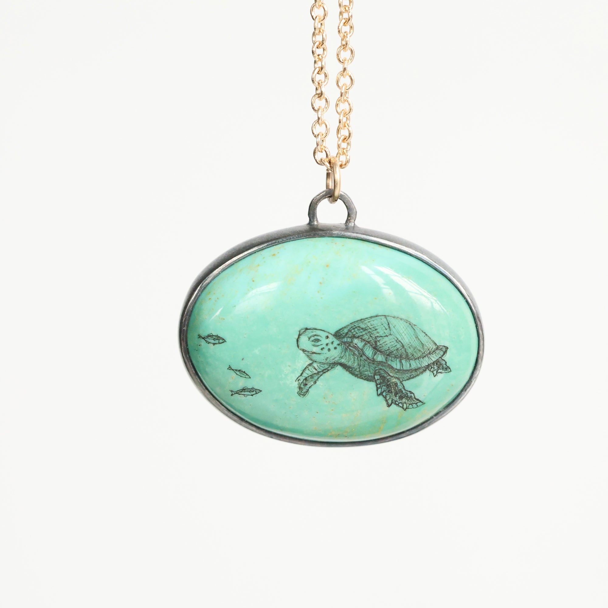 Necklace with a pendant featuring a turtle design on a light green background