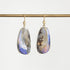 A pair of gold drop earrings with teardrop-shaped iridescent opal gemstones, hanging from a gold rod against a light gray background.