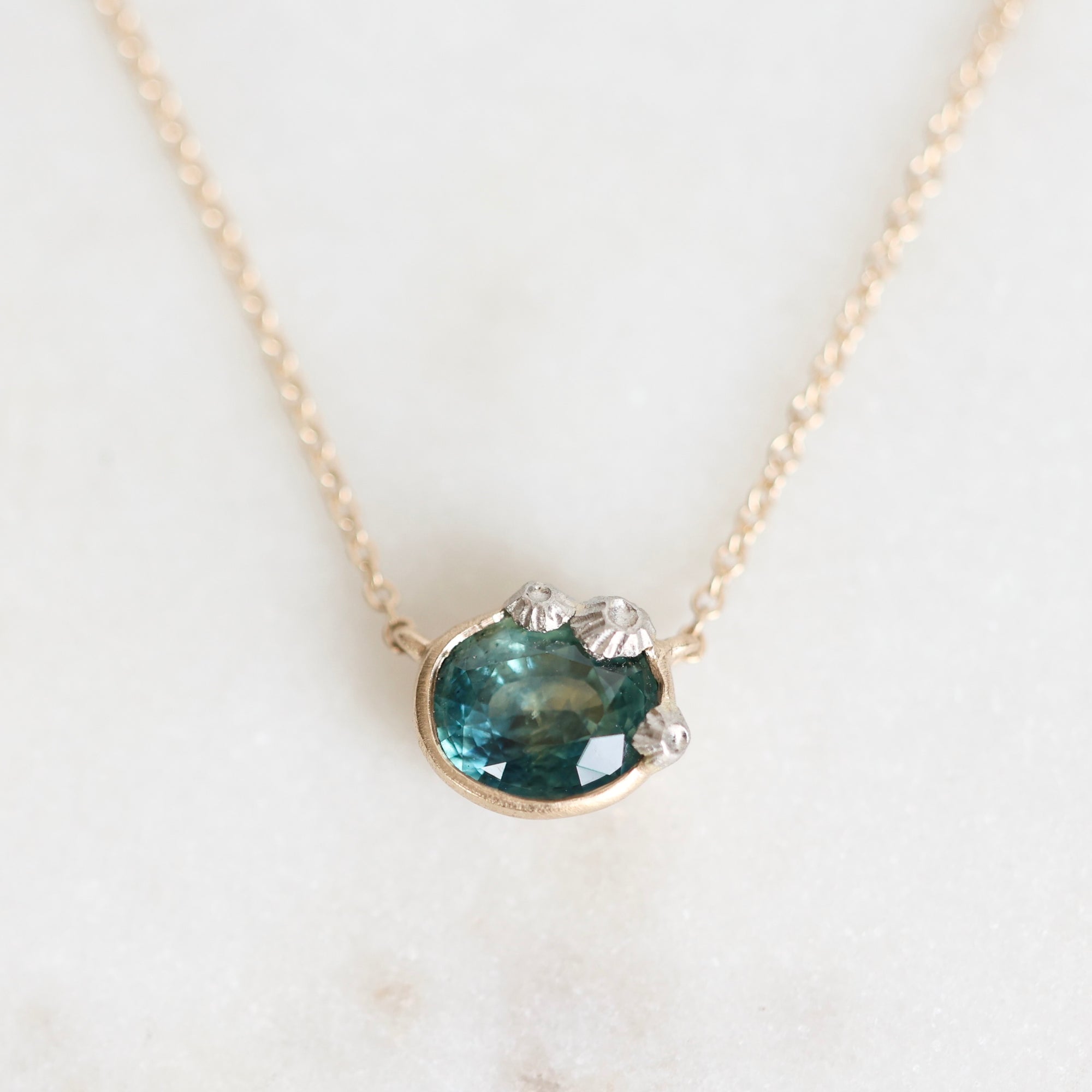 Sapphire necklace pendant with platinum barnacle details 