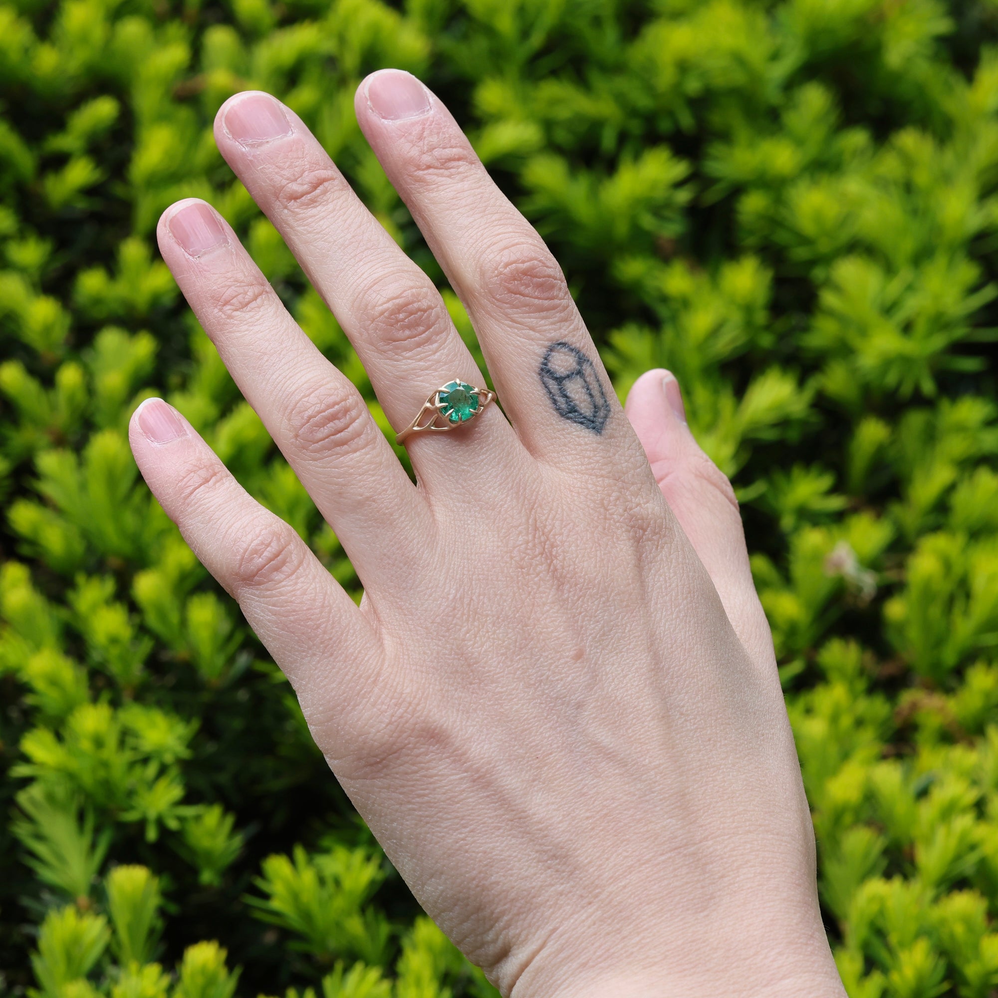 green gemstone ring on hand 