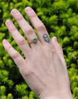 green gemstone ring on hand 