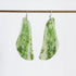 A pair of teardrop-shaped dangle earrings made from green and white marbled stone, hanging from silver fishhook wires against a plain white background.