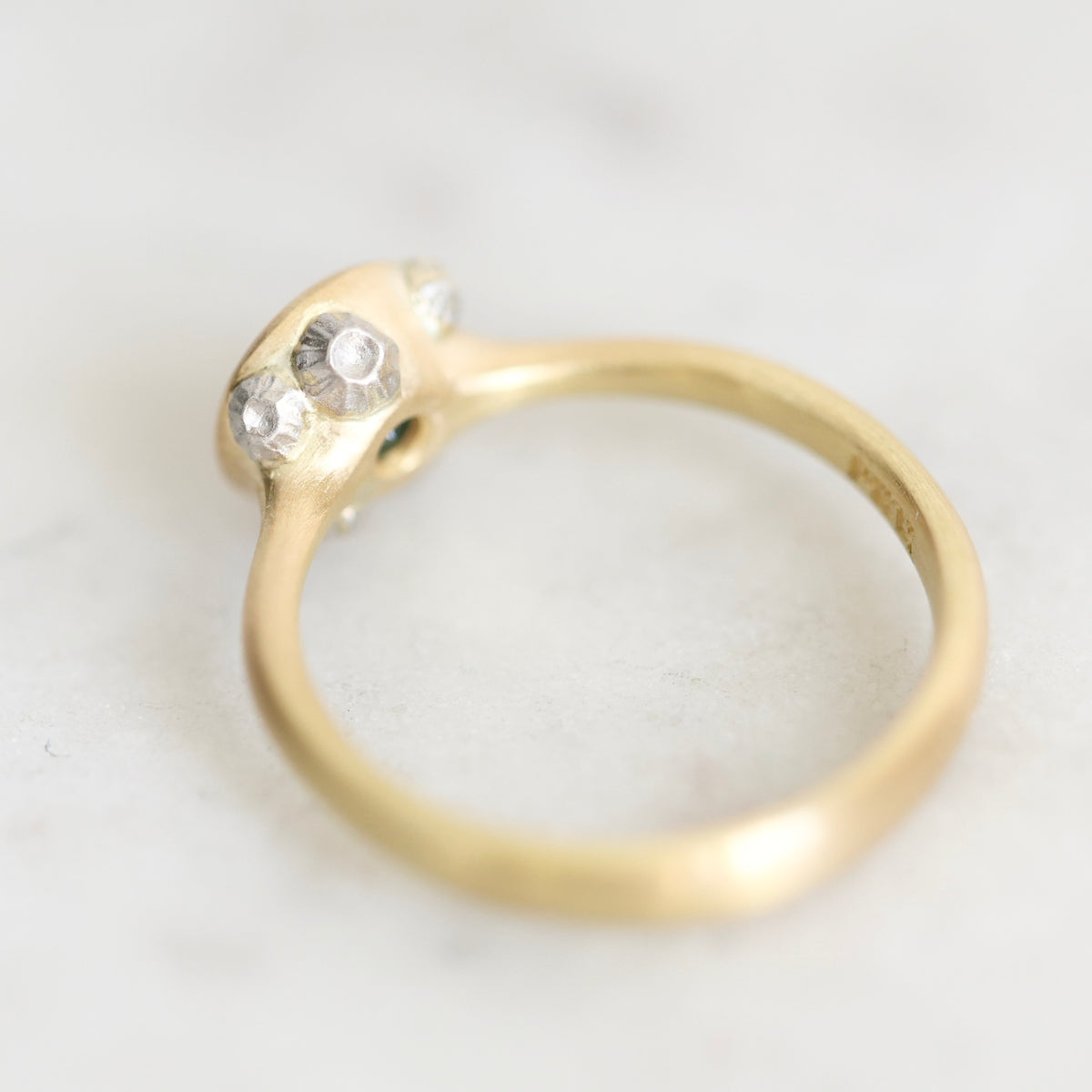 Back of gold ring with platinum barnacle details against a plain white background. 
