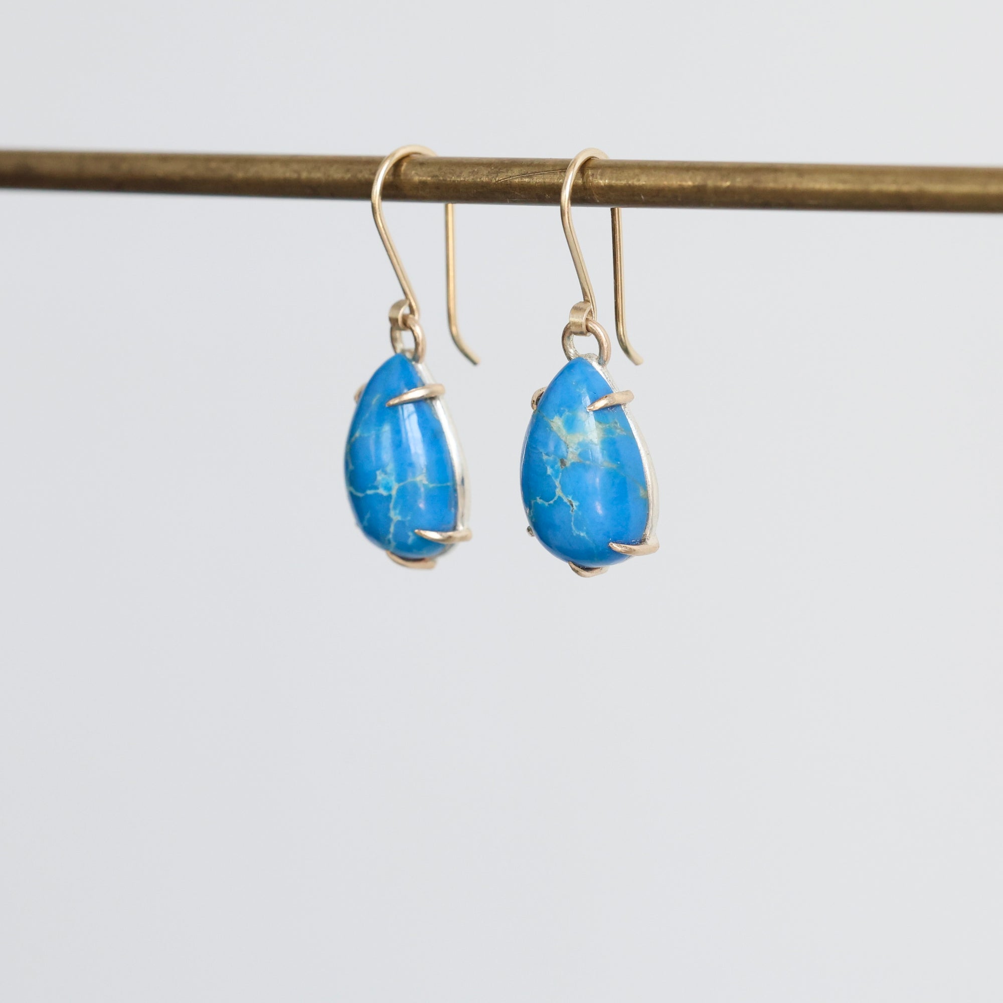 Pair of blue teardrop earrings on a white background