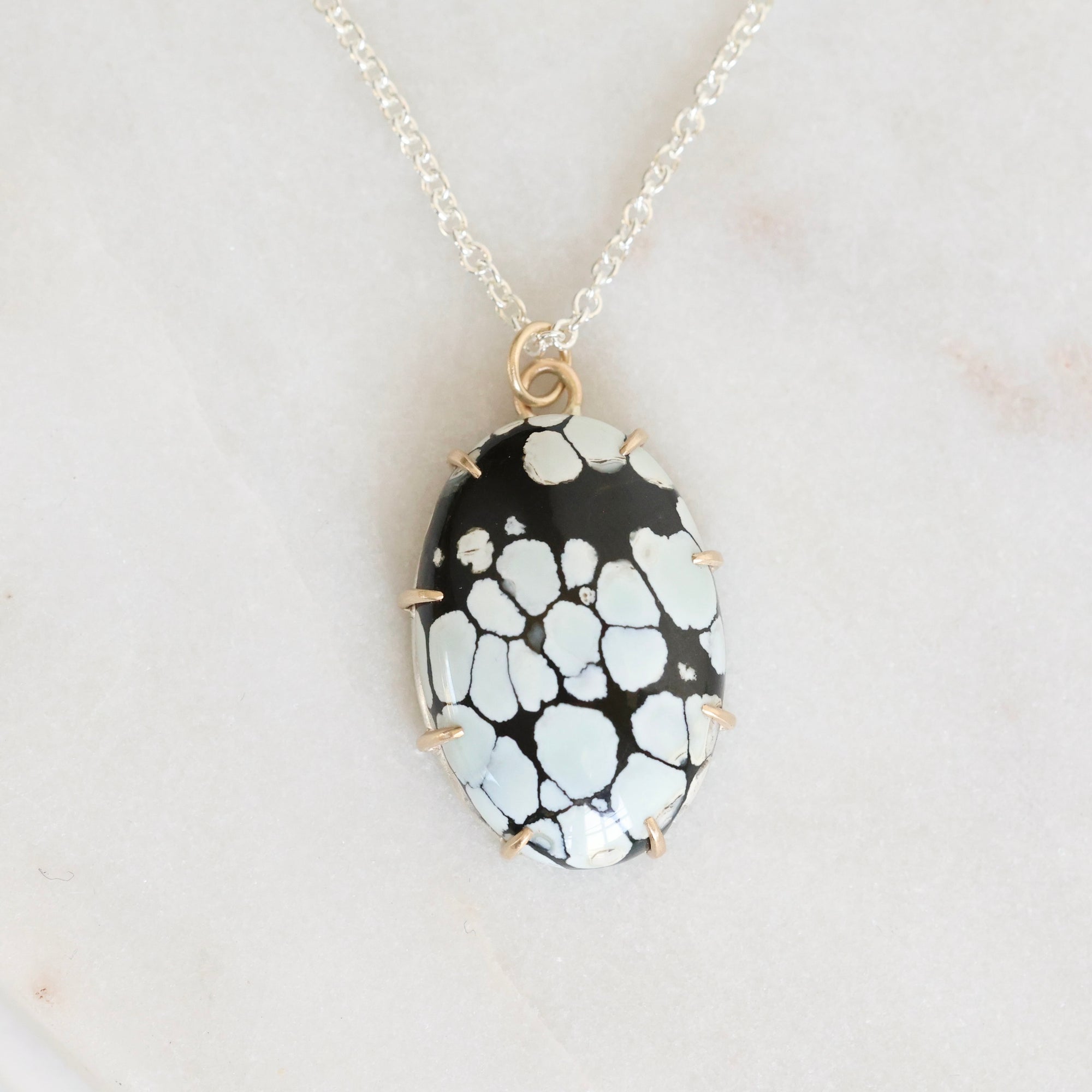 Necklace with a black and white patterned pendant on a light gray background