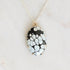 Necklace with a black and white patterned pendant on a light gray background