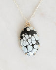 Necklace with a black and white patterned pendant on a light gray background