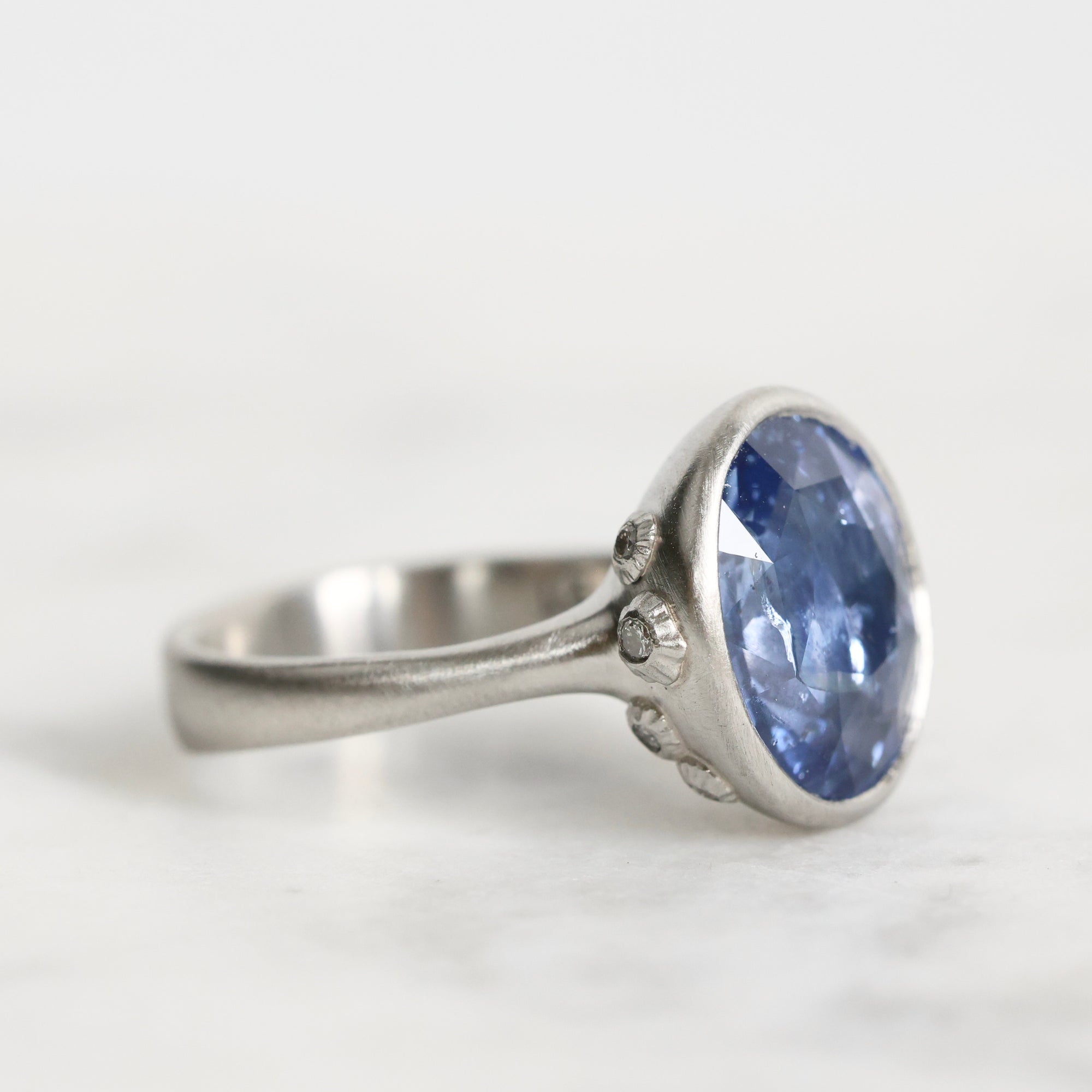 Silver ring with a blue gemstone on a white background