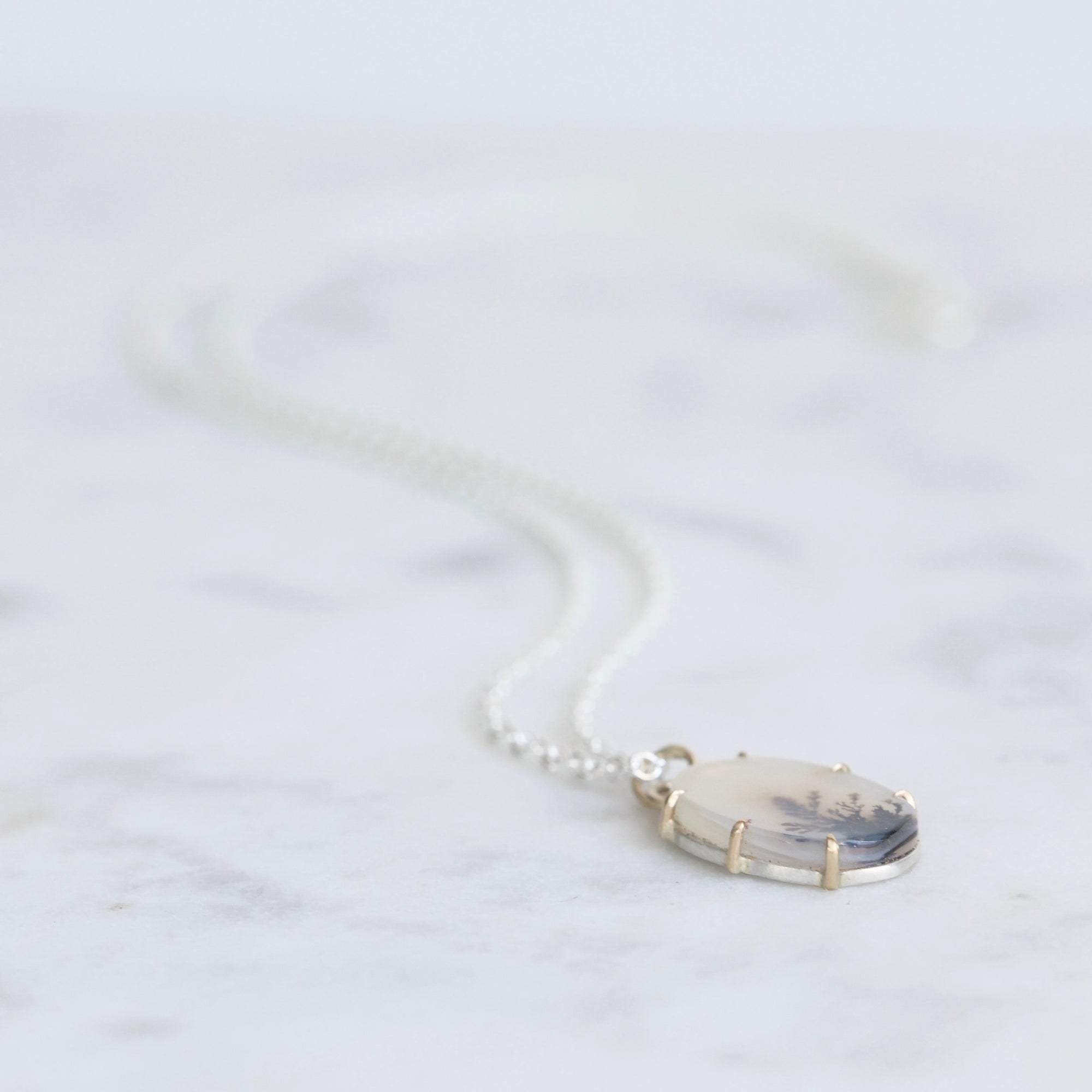 Necklace with a pendant on a marble surface