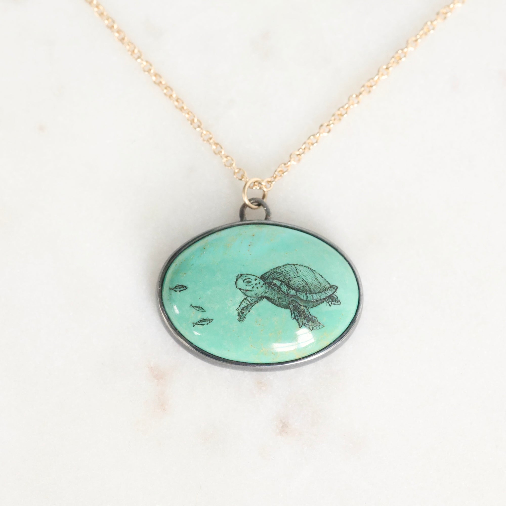 Necklace with a pendant featuring a turtle design on a light background