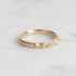 Gold ring with engraved design on a light gray background