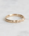 Gold ring with engraved design on a light gray background