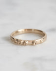 Gold ring with floral designs on a light gray background