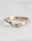 Gold ring with small barnacle details on a light gray background