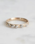 Gold ring with barnacle designs on a light gray background
