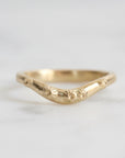 Gold ring with a unique design on a light gray background