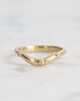 Gold ring with small diamonds on a light gray background