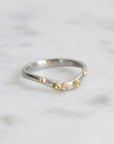 Silver ring with gold accents on a light gray background