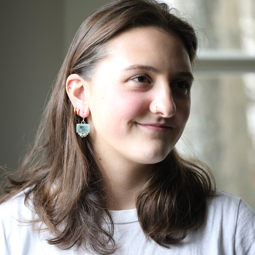 woman wearing rectangular blue earrings 