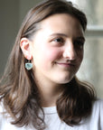 woman wearing rectangular blue earrings 