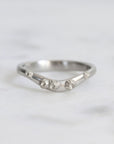 Silver ring with textured design on a white background