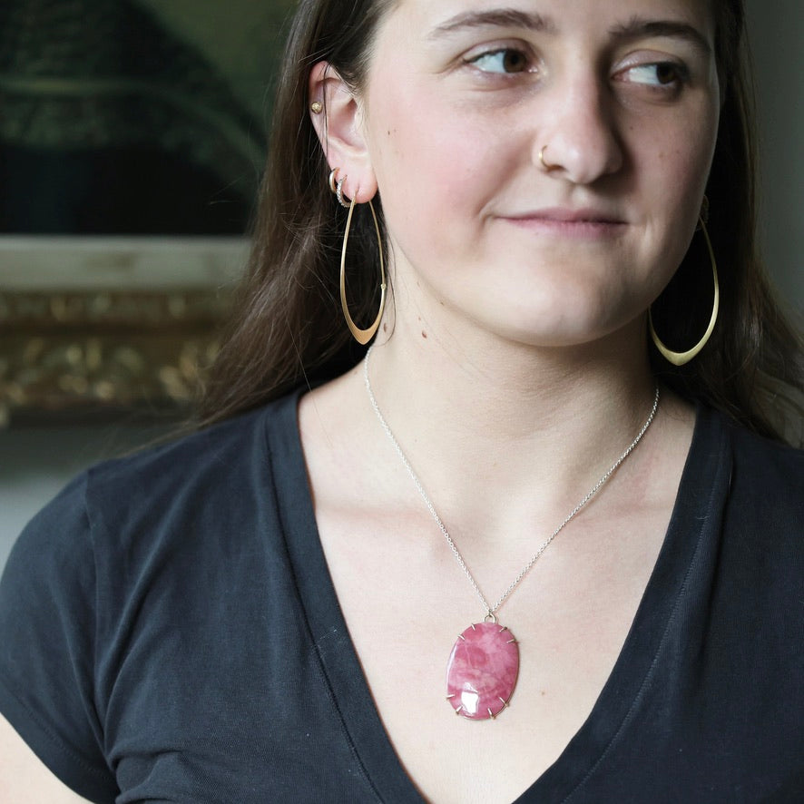 Woman wearing large pink stone pendant 