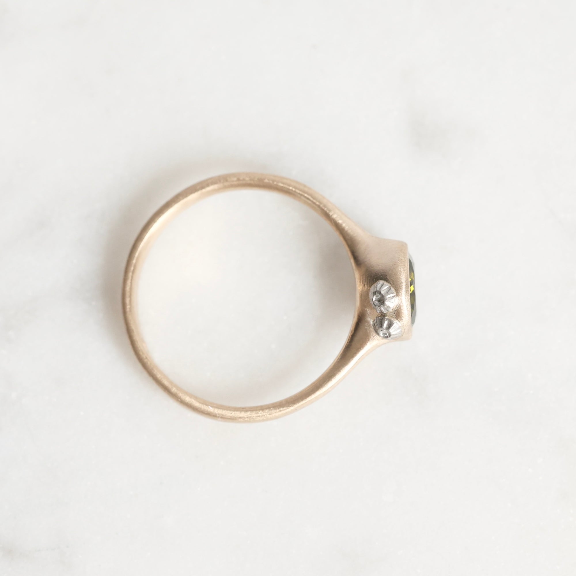 Gold ring with a diamond on a white background