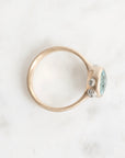 Gold ring with a blue gemstone on a white background
