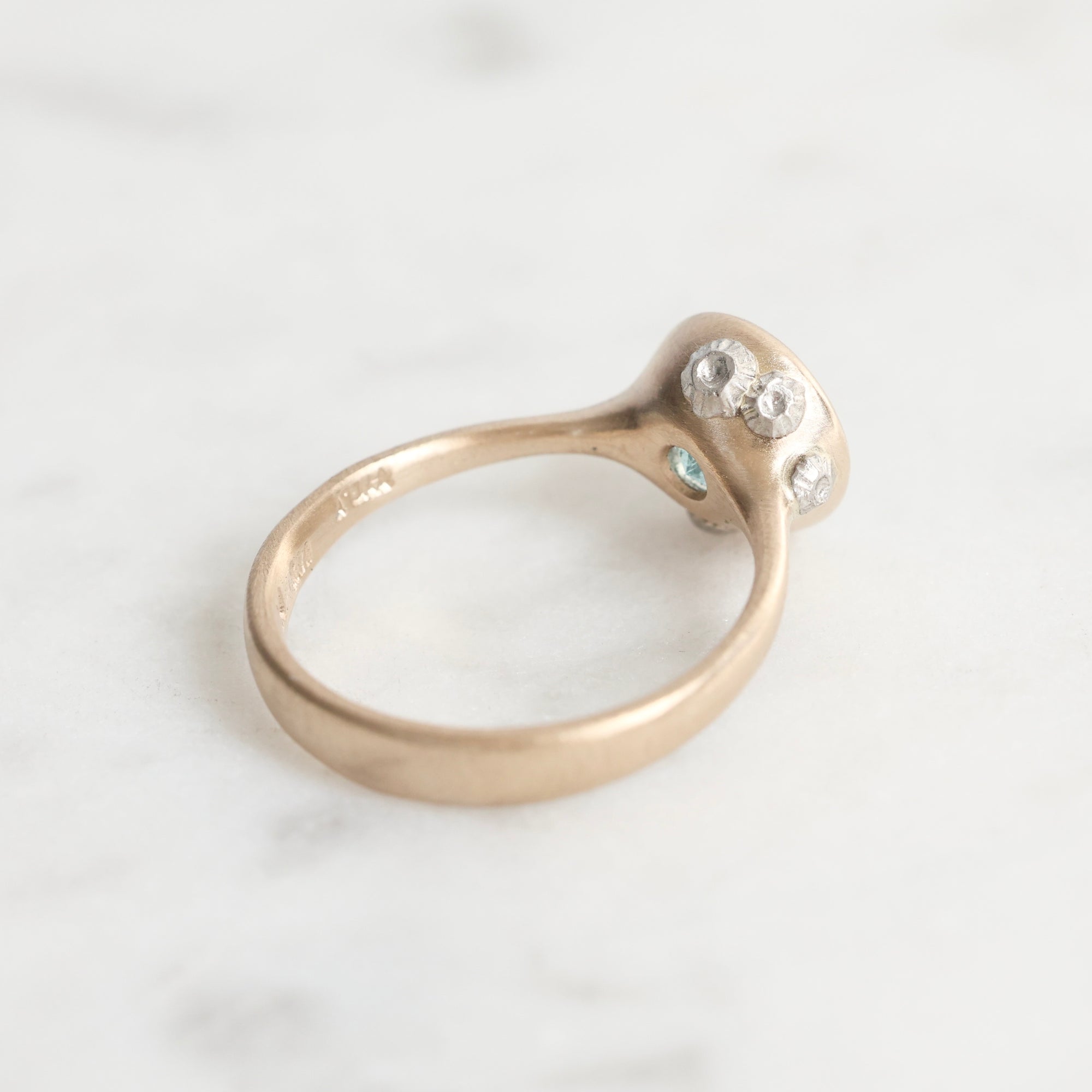 Gold ring with small diamonds on a white background