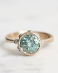 Gold ring with a blue gemstone on a light background