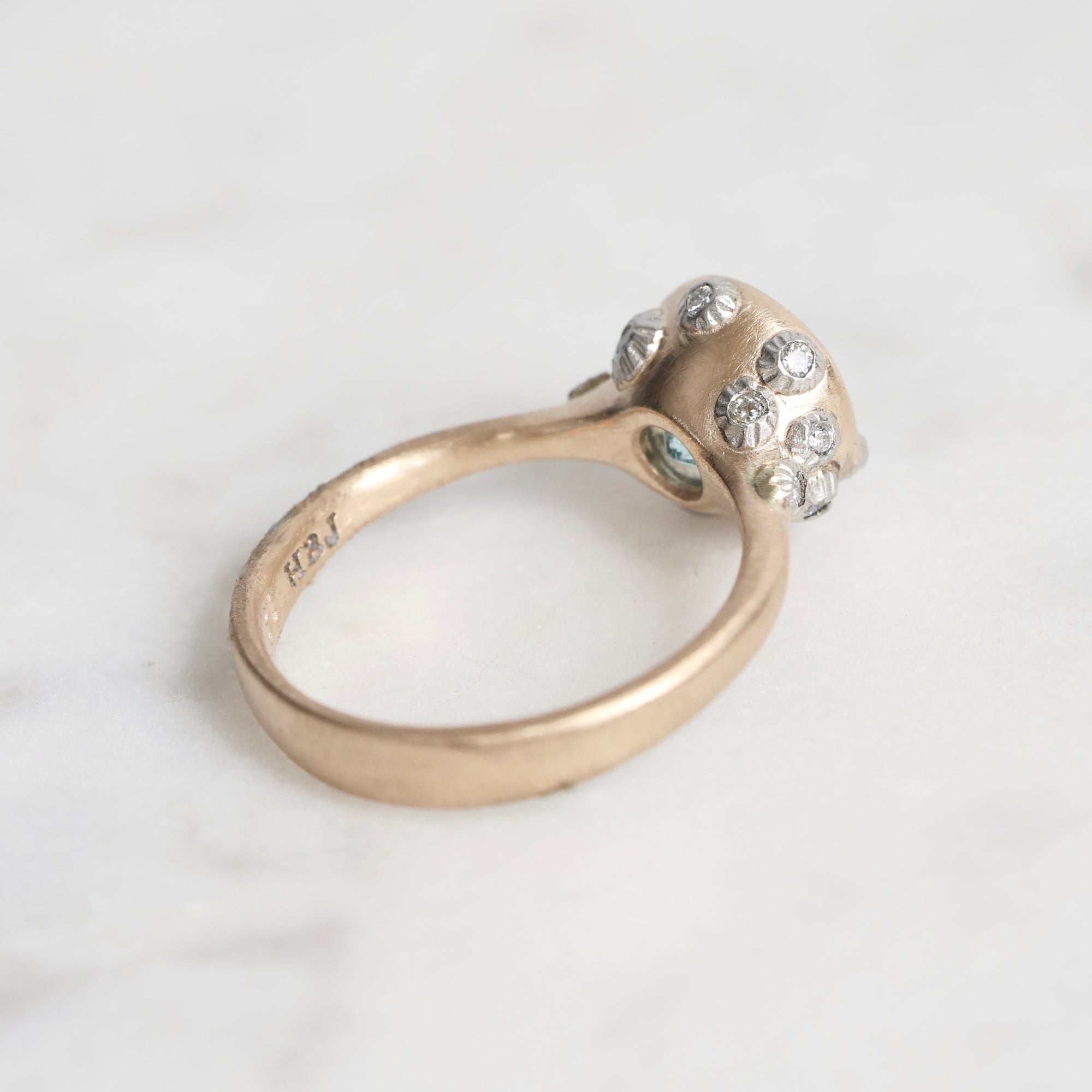 Gold ring with gemstones on a light gray background
