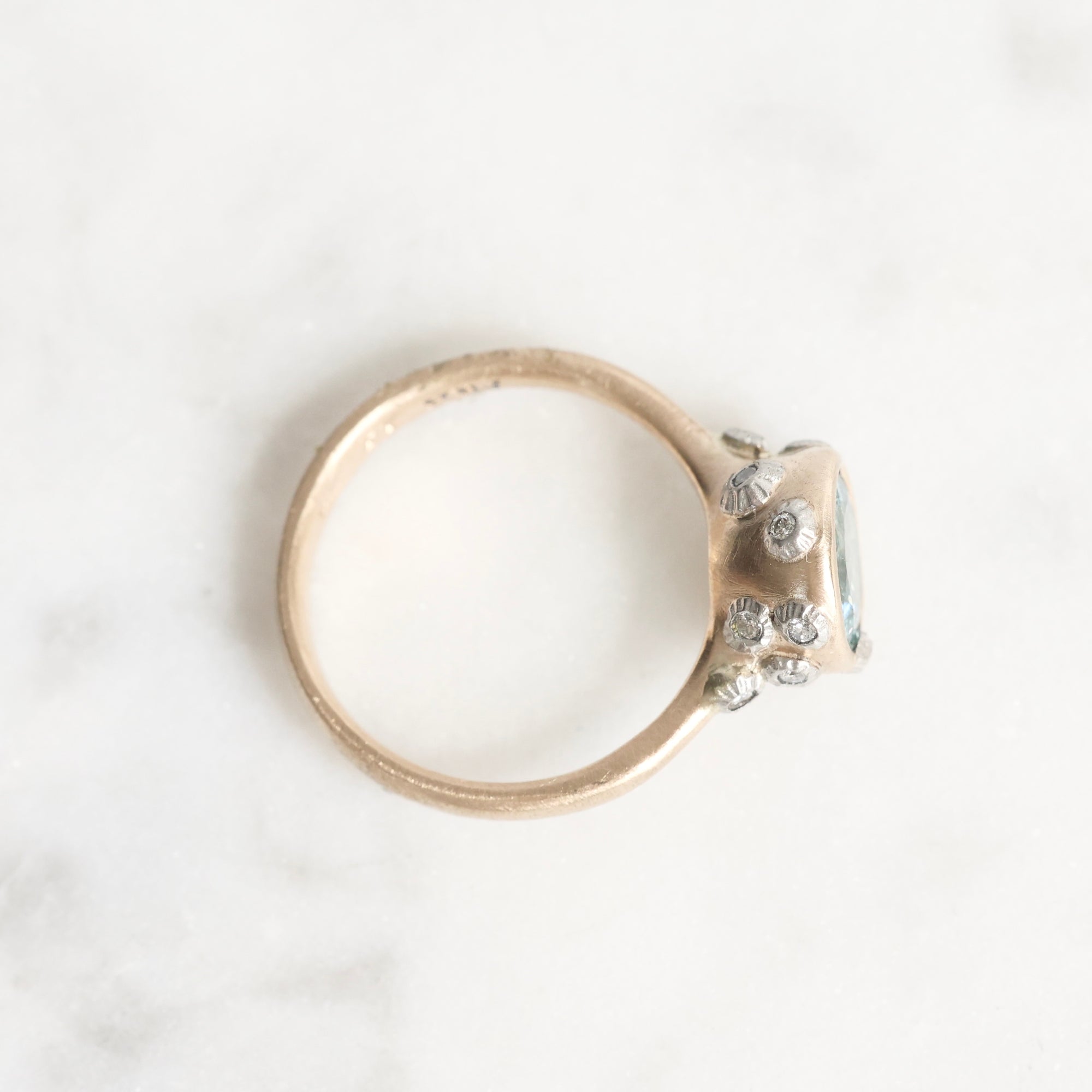 Gold ring with small diamonds on a white background