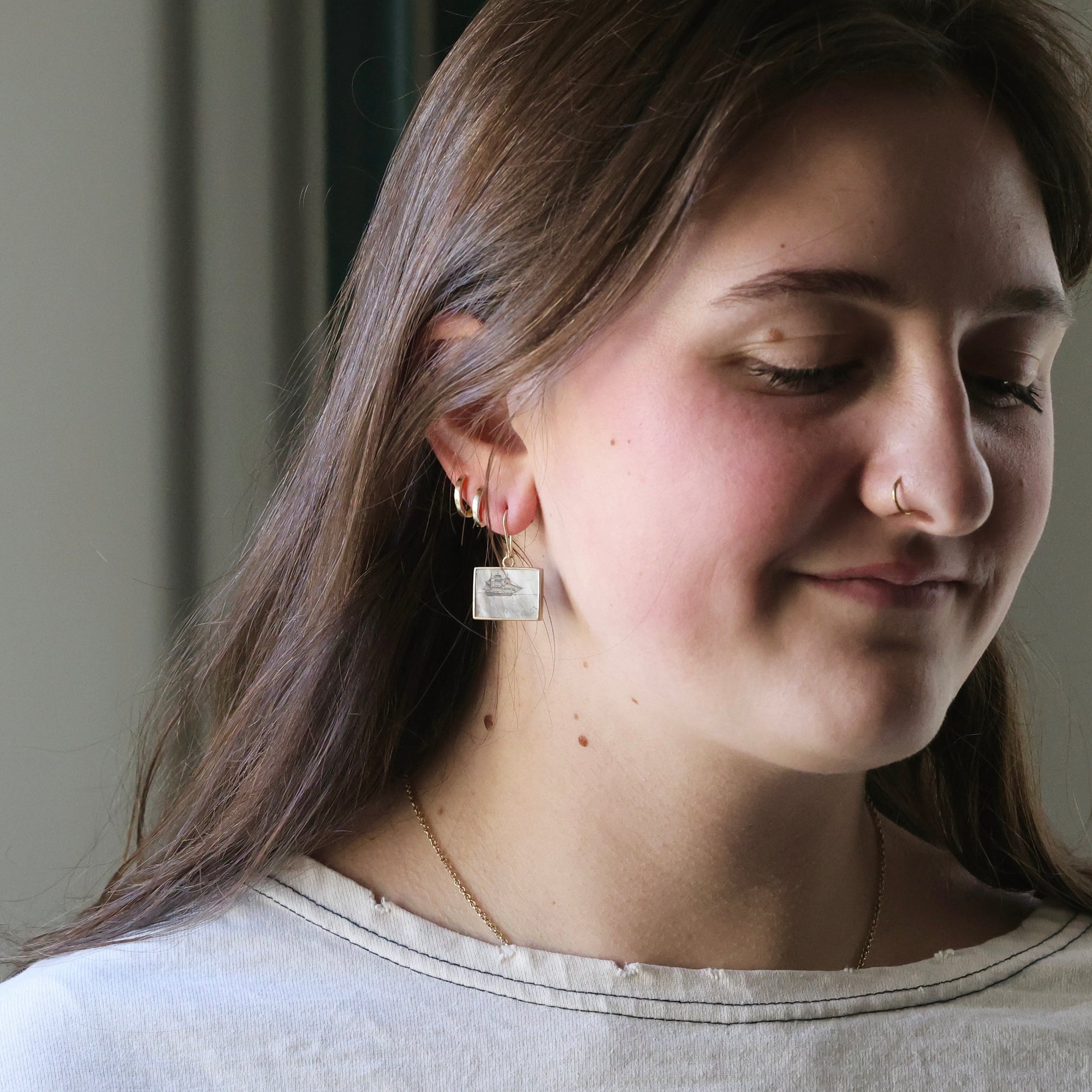 Woman wearing earrings with a neutral background
