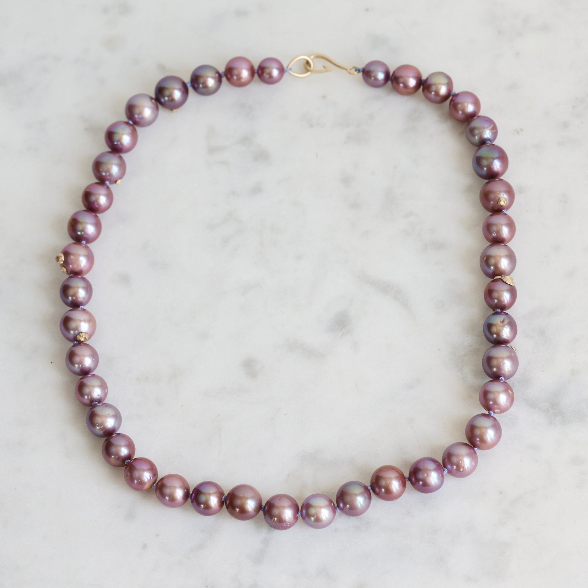 Pink pearl strand with lavender thread and gold barnacles 