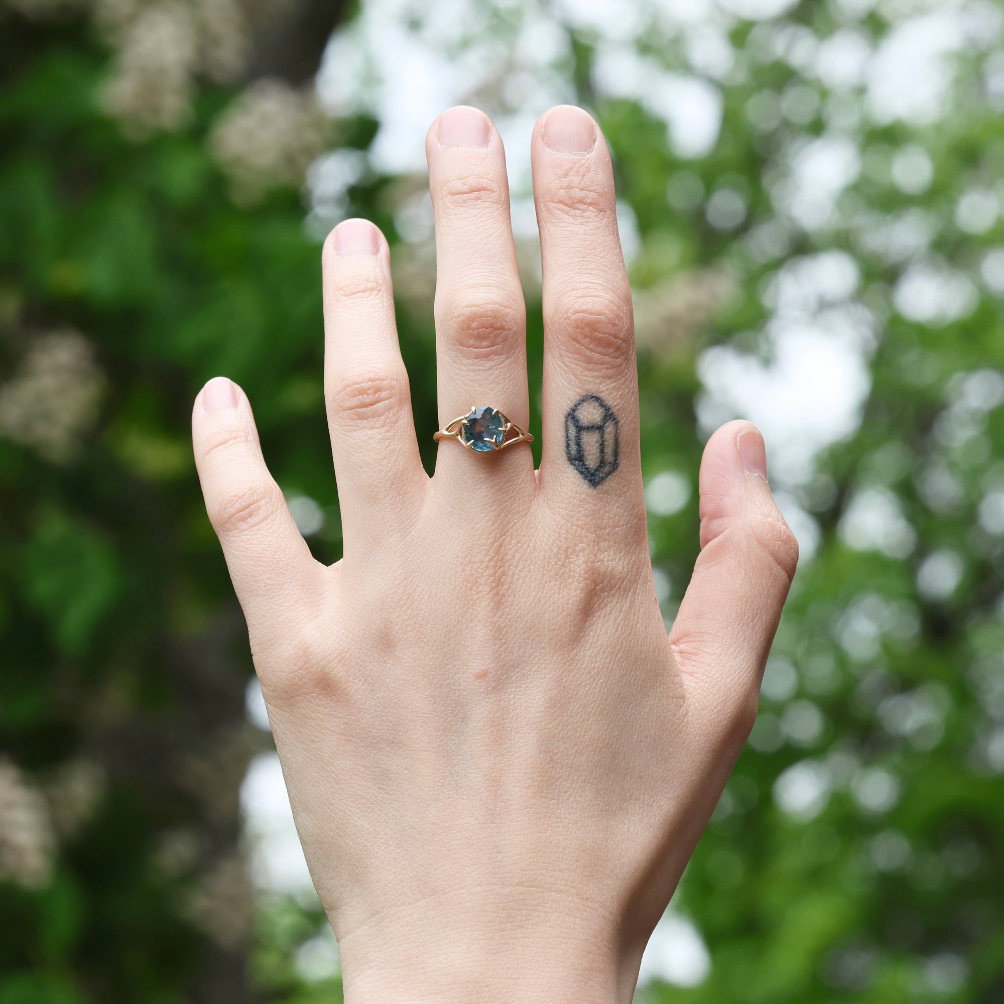 gold ring with blue gemstone on hand