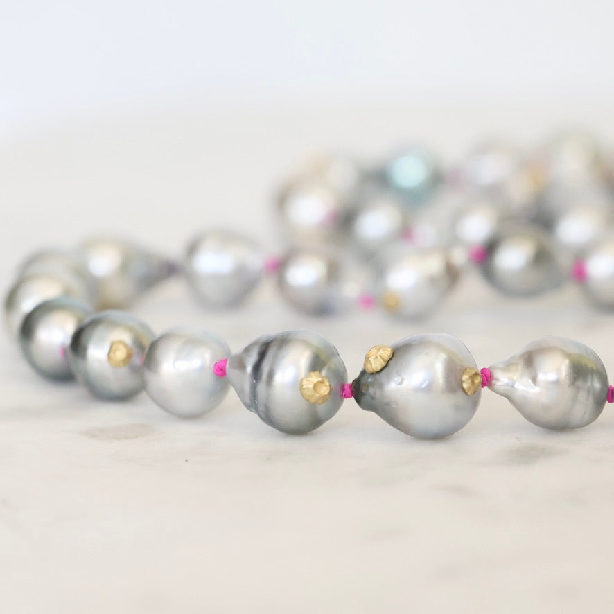 Pearl necklace with gold accents on a light background