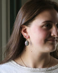 Woman wearing earrings with a neutral background