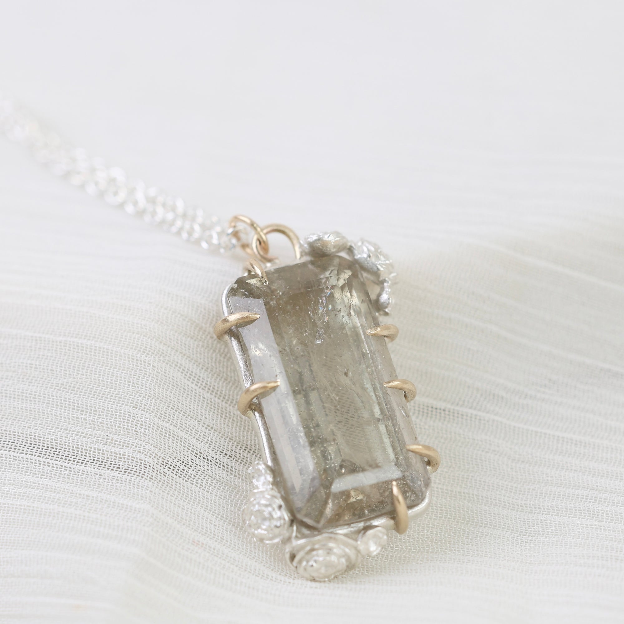 Crystal pendant necklace on a white fabric background