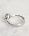 Silver ring with a small gemstone on a light gray background