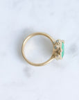 Large green gemstone ring surrounded by gold barnacles with diamonds 