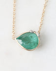 Necklace with a green teardrop pendant on a white background