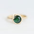 Green gemstone set in gold bezel with barnacle details