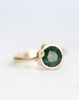 Green stone ring with gold bezel and barnacle accents 