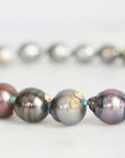 Close-up of a necklace with pearls and gold accents on a light background