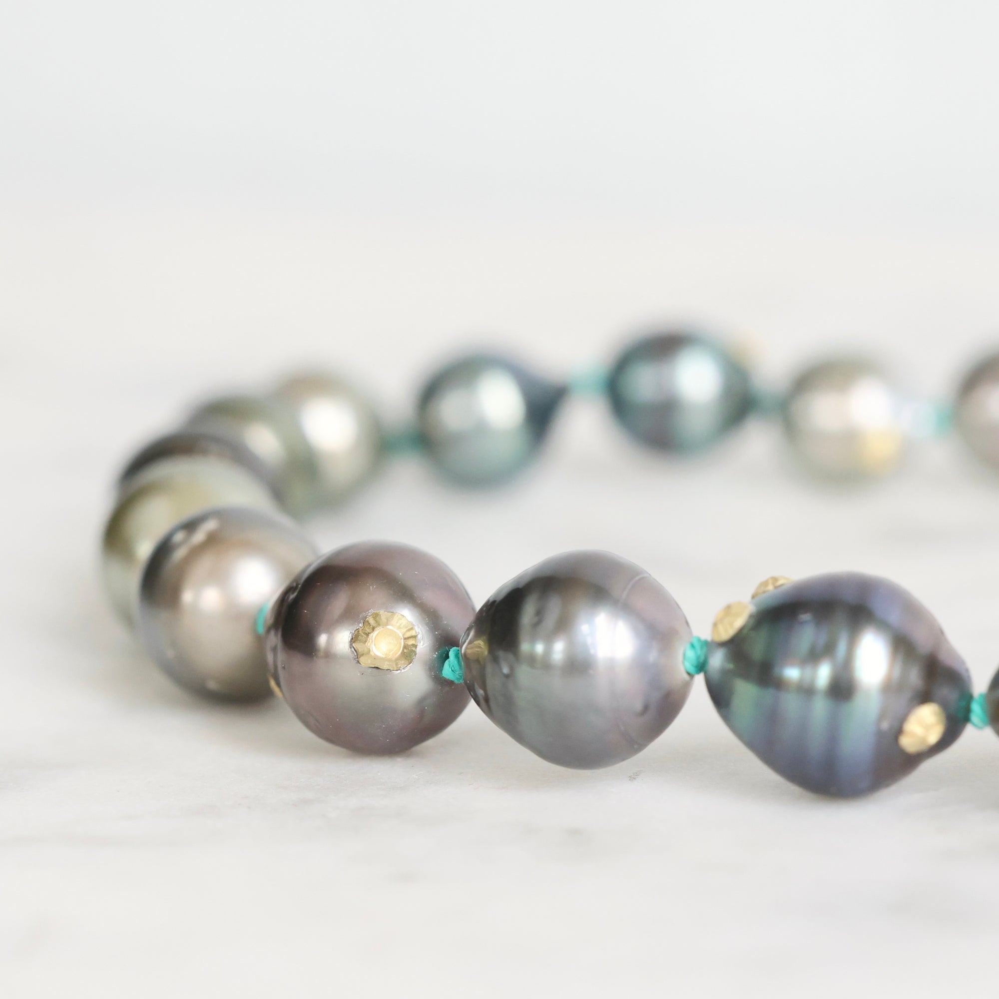 Pearl necklace with gold accents on a light background