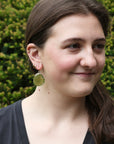 woman wearing large green gemstone earrings