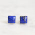Pair of square blue gemstone earrings on a white background