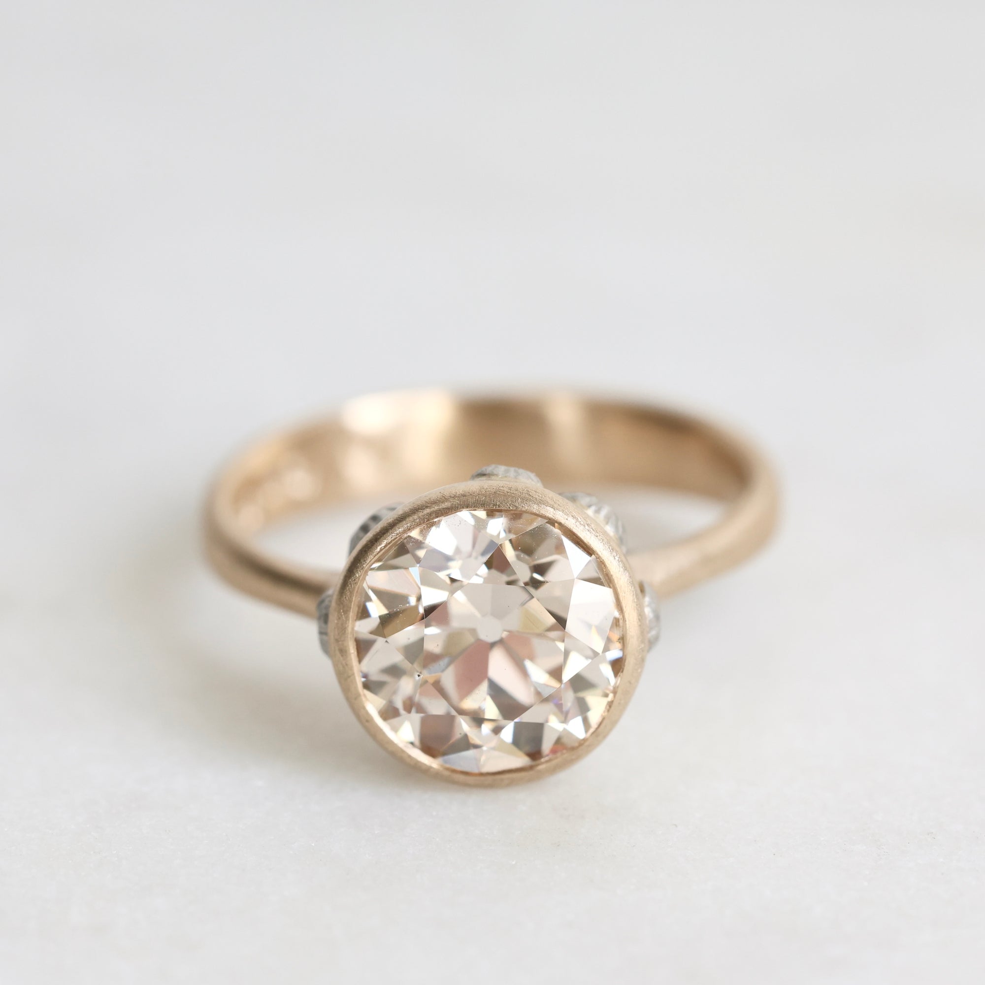 gold ring facing forward with a diamond and platinum barnacles against a white background